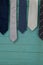 Close up of neckties hanging on green wooden wall