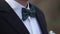 Close-up on nerd, man in bow tie. Man`s hands touches bow-tie on a suit or tuxedo. man in a shirt and bow tie