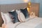 Close-up of new blanket with decorative pillows, fabric dotted headboard in bedroom in sample model of hotel or apartment