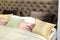 Close-up of new blanket with decorative pillows, wooden headboard in bedroom in sample model of hotel or apartment