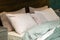 Close- up of a new mint- colored blanket with decorative pillows, wooden headboard in bedroom in sample model of house or
