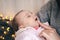 Close-up of a newborn baby girl falls asleep in her mother's arms.