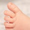 Close-up of a newborn baby`s toes.  Close-up of a newborn baby`s foot. The little leg of a white baby.  A tiny baby foot. Health
