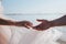 Close-up of newlywed loving couple holding hands on the beach. concept of love.