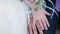 Close up of newlyweds hands with rings gently touch each other.