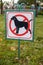 Close-up of no dog sign. Street pointer on a background of green grass. Ban on defecation and running of pets on park lawns and