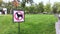 Close-up of no dog sign. Street pointer on a background of green grass. Ban on defecation and running of pets on park lawns and