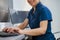 Close up of nurse on Duty working on computer at the Reception Desk in modern clinic