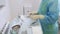 Close-up nurse hands in sterile gloves prepares medical instruments for sclerotherapy surgery