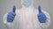 Close up of a nurse in a protective suit doing a thumbs up gesture. Covid 19