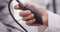 Close-up of nurse\'s hand pumping blood pressure monitor