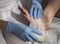 Close-up Of A Nurse Tying Bandage On Patient`s Foot