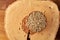 Close-up oat groats heaped in a wooden bowl on wooden log, selective focus.