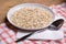 Close up of oatmeal in plate with spoon on table