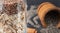 Close up oats and flaxseeds in a glass with unfocused wooden bowl of chia seeds on background.