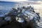 Close Up Ocean Wave Strikes Glass Ball on Sand in Motion