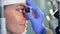 Close up of an ocular in doctor`s hands being used for young woman`s eyes check up