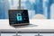 Close up of office workplace with laptop and abstract glowing padlock on screen, blurry city view background. Secure, safety and