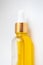 Close-up oil serum essence in glass bottle. Macro skincare product vertical photo