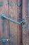 Close-up of old brown wooden massive gate, closed door, handmade iron handles and knockers