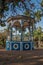 Close-up of an old colorful gazebo in the middle of verdant garden full of trees, in a sunny day at SÃ£o Manuel.