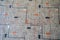 Close up of old, cracked and peeling linoleum with a gray, orange and black square design