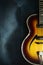 Close-up of old electric jazz guitar on a dark blue background