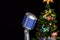 Close-up of an old-fashioned microphone with blurry Christmas tree in the background