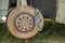 Close-up of old forsaken abandoned rusty broken trash car brake disc detail without rubber tire outdoors in field