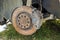 Close-up of old forsaken abandoned rusty broken trash car brake disc detail without rubber tire outdoors in field