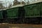 Close up of old green rail freight train in motion transporting cargo
