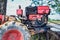 Close up of the old red tiller tractor or walking tractor parked under the tree in the fields at countryside, Thailand