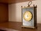 Close-up of old vintage table black marble mechanic clock on wooden shelf with golden dial face and metallic circle for moving