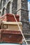 Close-up of old vintage travel suitcases fastened to the roof of a car with a rope and in the background the aqueduct of Segovia,