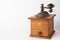 Close-up of old wooden coffee grinder, sideways, with unfocused handle, on white background,