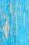 Close up of a old wooden door, teal blue paint peeling off; text