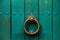 Close up old wooden green door with a knocking ring