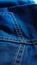 Close-up old work uniform with scuffs on a lowercase seam of blue denim