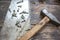 Close-up of an old working hammer, saw with traces of rust, screws on a wooden surface. Home craftsman`s tool. Selective focus