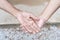 Close-up of old and young holding hands. Middle-aged mommy\'s wrinkled hands holding young daughters,