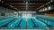 Close-up Olympic pool with lanes ready for professional swimmers. Nobody blue water background