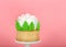 Close up of one giant rose cup cake on pedestal pink background