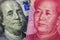 Close up of one hundred Dollar and 100 Yaun banknotes with focus on portraits of Benjamin Franklin and Mao Tse-tung/USA vs China t