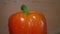 Close-up of one orange bell pepper on a rotating plate