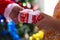 Close-up of one person\'s hands handing a gift to another. Christmas time
