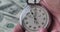 Close-up of one person starting up a stopwatch on money dollars background. Time is money. Deadline concept.