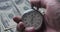 Close-up of one person starting up a stopwatch on money dollars background. Time is money. Deadline concept.