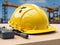 Close up one yellow hard hat construction site with new construction building background.
