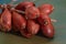 Close-up of onions. Shallots tied in bunches on a green wooden table. Shallow depth of field. Art image of a shallot.