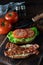 Close up of an open faced toasted bacon and tomato sandwich on a wooden board, ready for eating.